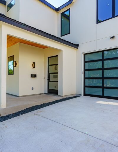 Modern two-story house with a frosted glass panel garage door and a covered entrance.