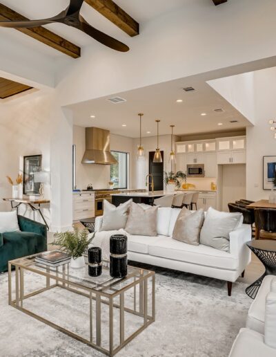Modern living room interior with white walls, stylish furniture, and ceiling beams.