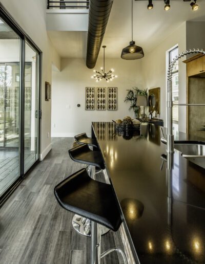 Modern kitchen interior with a sleek island, bar stools, and open-plan design.