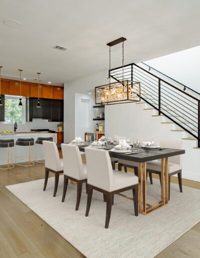 Modern dining area with adjacent kitchen and staircase.