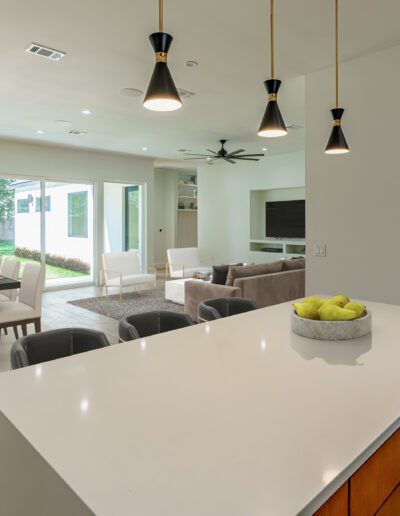 A modern open-plan living space with a kitchen island, dining area, and living room.