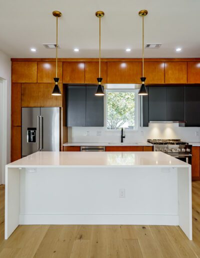 Modern kitchen interior with wooden cabinets and white island.