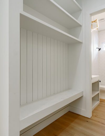 Walk-in closet with built-in bench leading to an en suite bathroom.