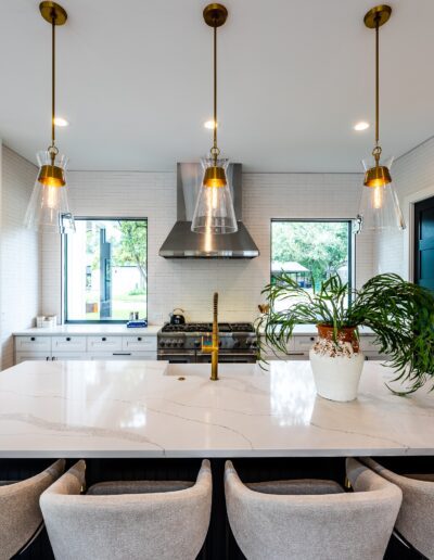 Modern kitchen interior with a large island, pendant lighting, and contemporary furnishings.