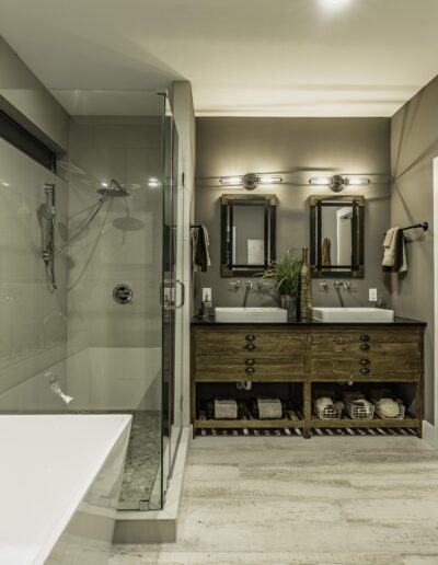 A modern bathroom with a double vanity, walk-in shower, freestanding tub, and neutral color palette.