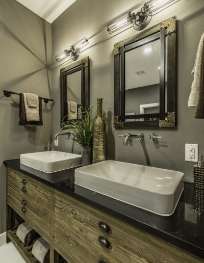 Modern bathroom with twin vessel sinks, wooden vanity, and wall-mounted mirrors.